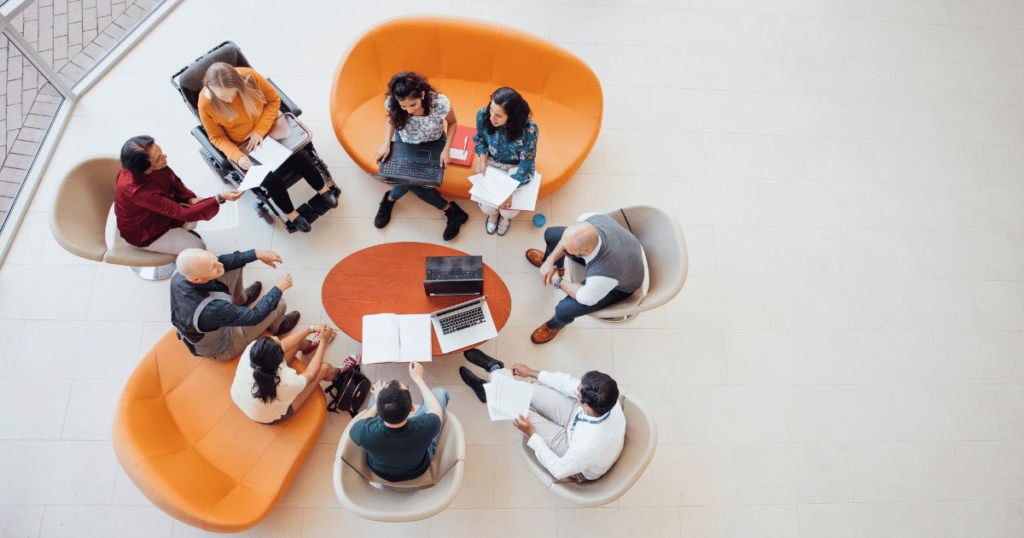 Birds-eye view of a team of nine people having a meeting