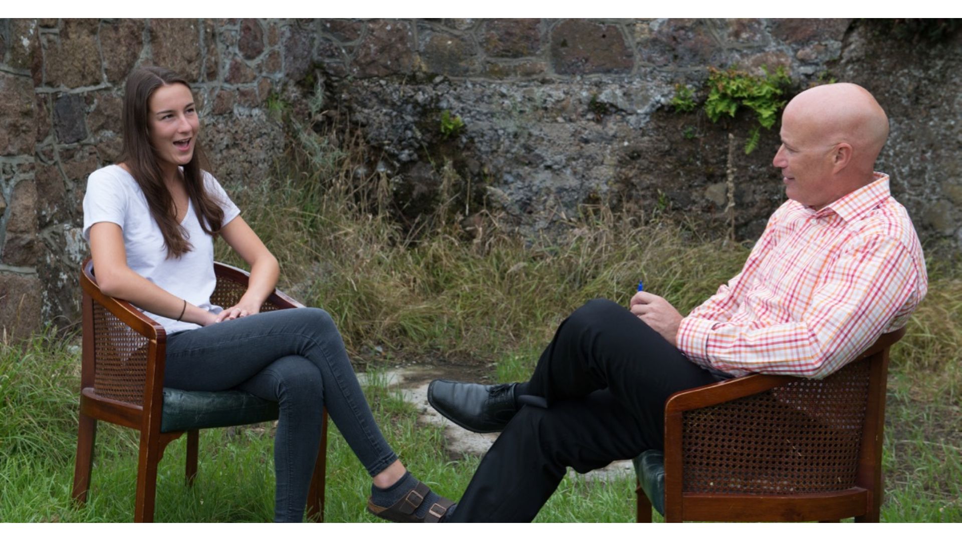 Woman and man sitting in chairs outdoors